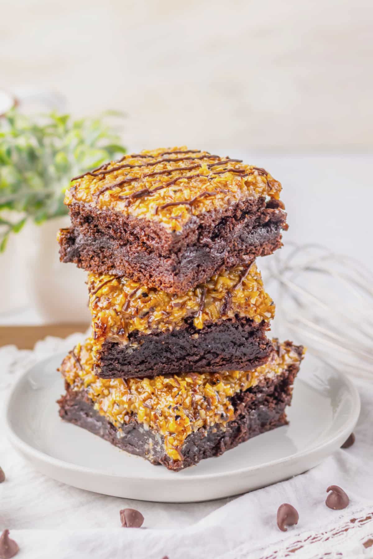 Three brownies stacked on top of each other on a small plate.