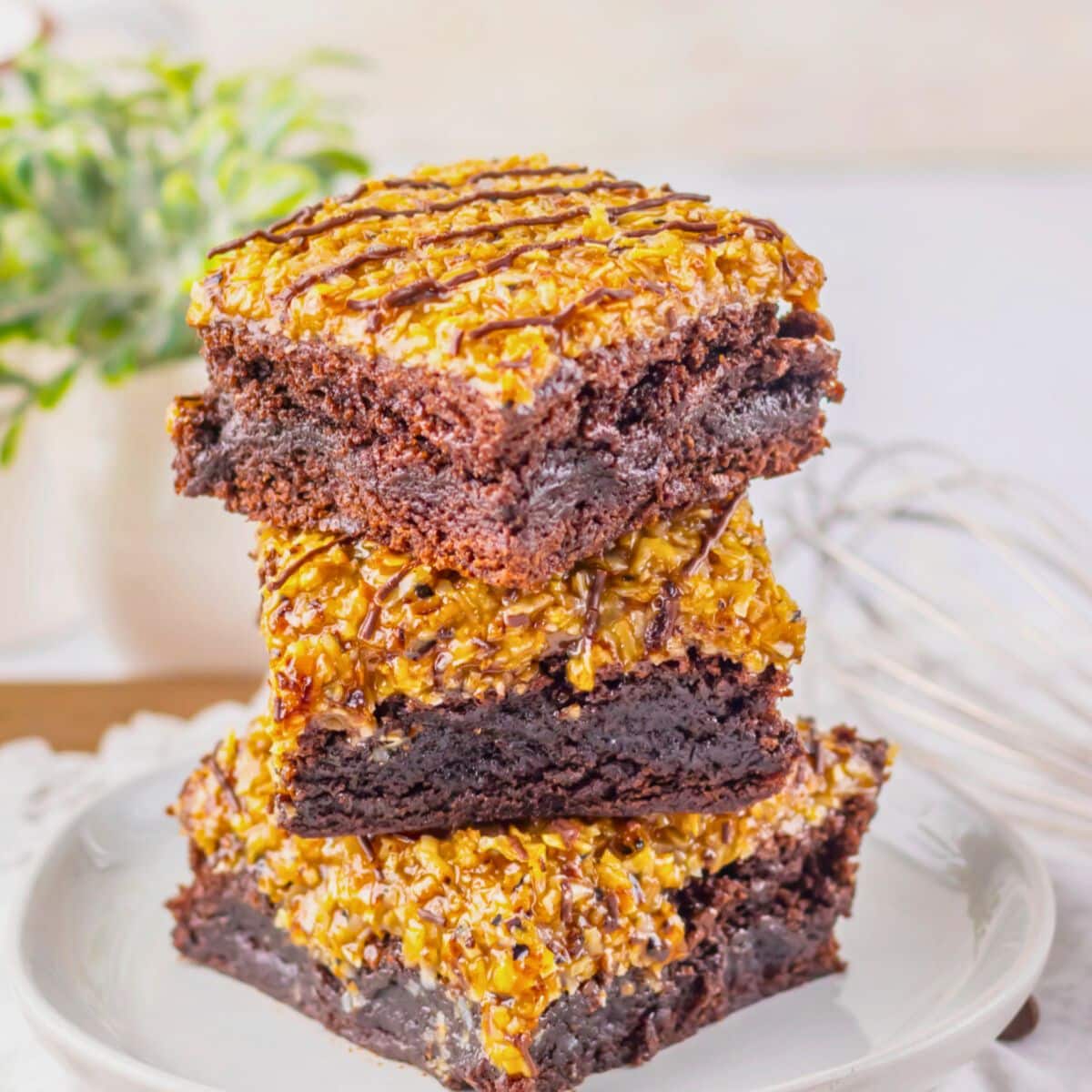 Three brownies stacked on top of each other on a small plate.