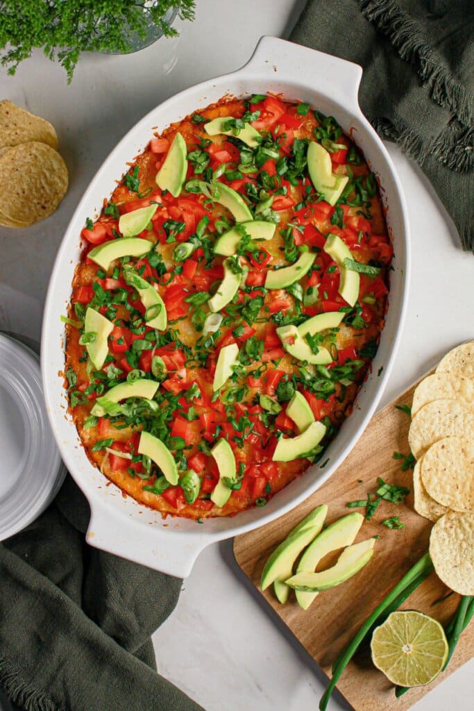 Avocado and tomatoes being added to top of appetizer.