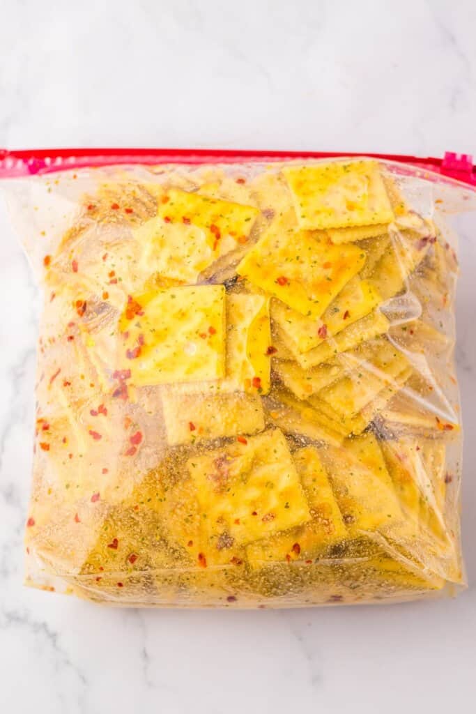 Saltines being marinated in a storage bag.