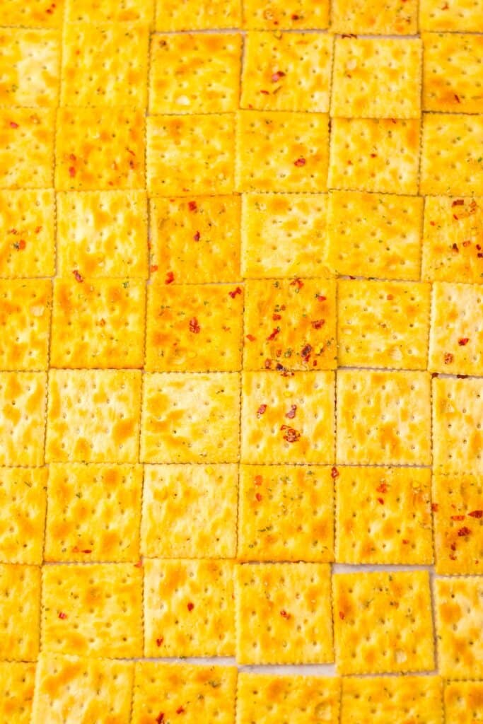 Saltines on a baking sheet in rows.