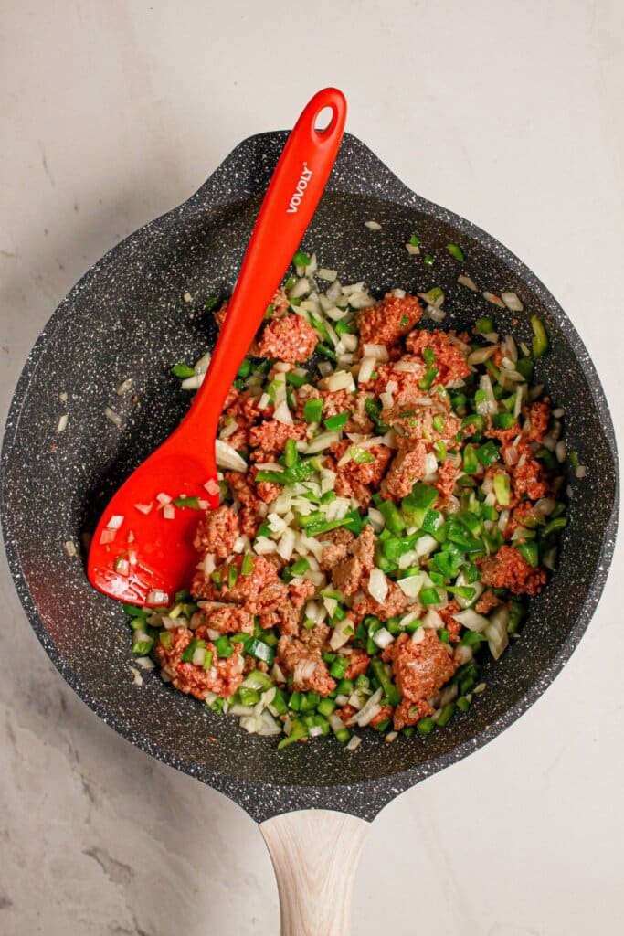Meat and veggies being cooked in a large skillet.