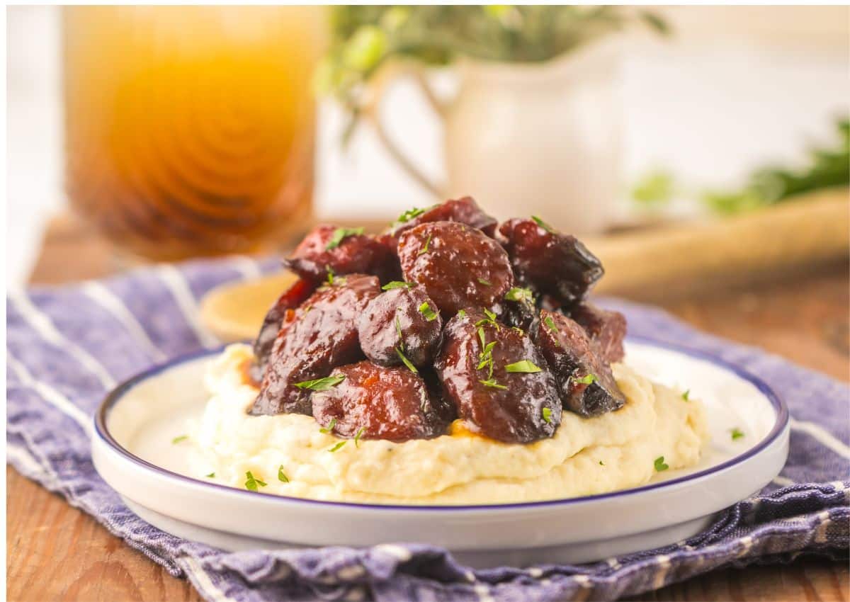 Brown sugar kielbasa on a bed of mashed potatoes.