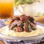 Brown sugar kielbasa on a bed of mashed potatoes.