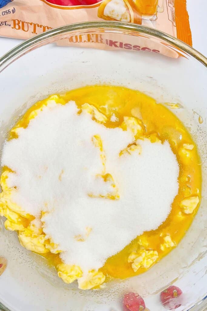Butter and sugar being creamed together in a glass bowl.