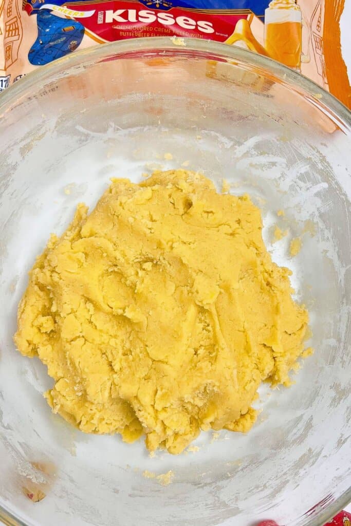Dry ingredients being added to dough in a mixing bowl.