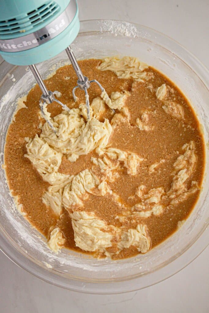 Frosting being mixed in a glass bowl.
