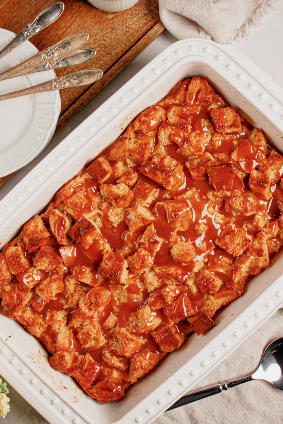 Caramel bread pudding in a white baking dish.