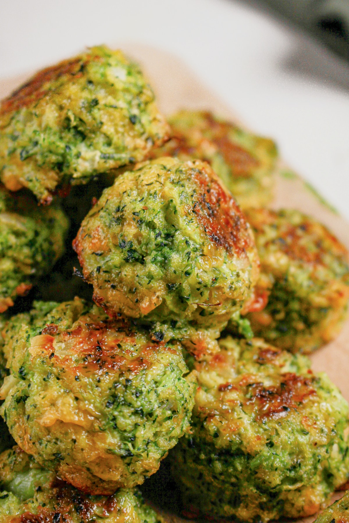 Cheesy broccoli bites on a wooden cutting board.
