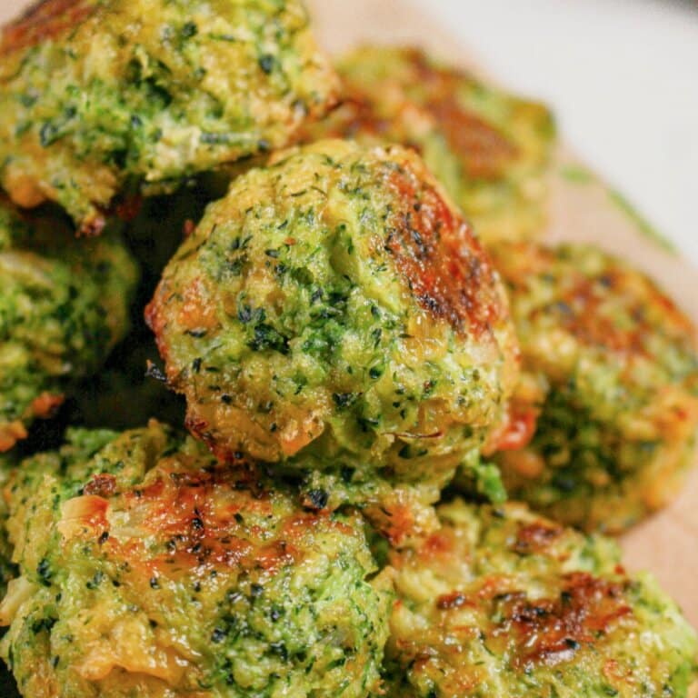 Cheesy broccoli bites on a wooden cutting board.