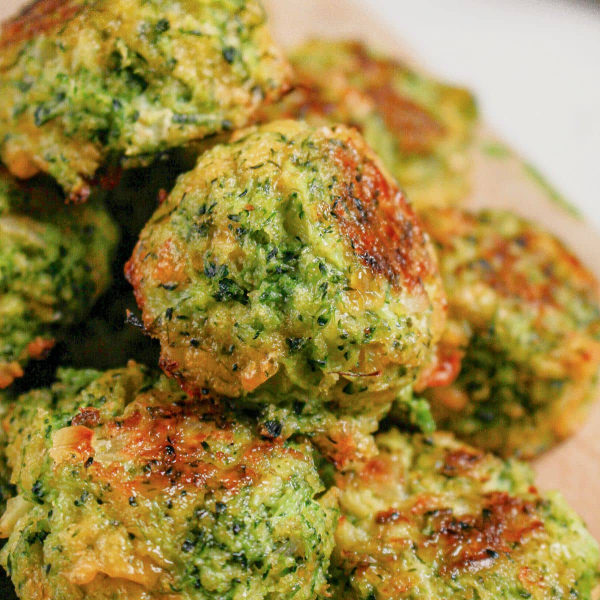 Cheesy broccoli bites on a wooden cutting board.