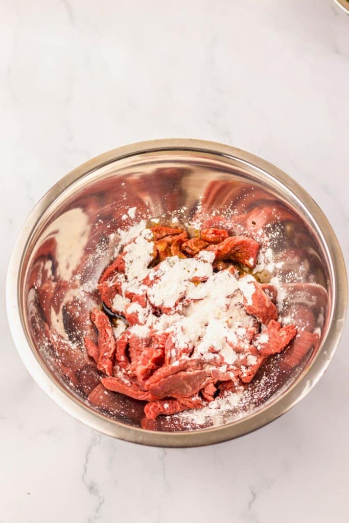 Meat being coated in cornstarch.