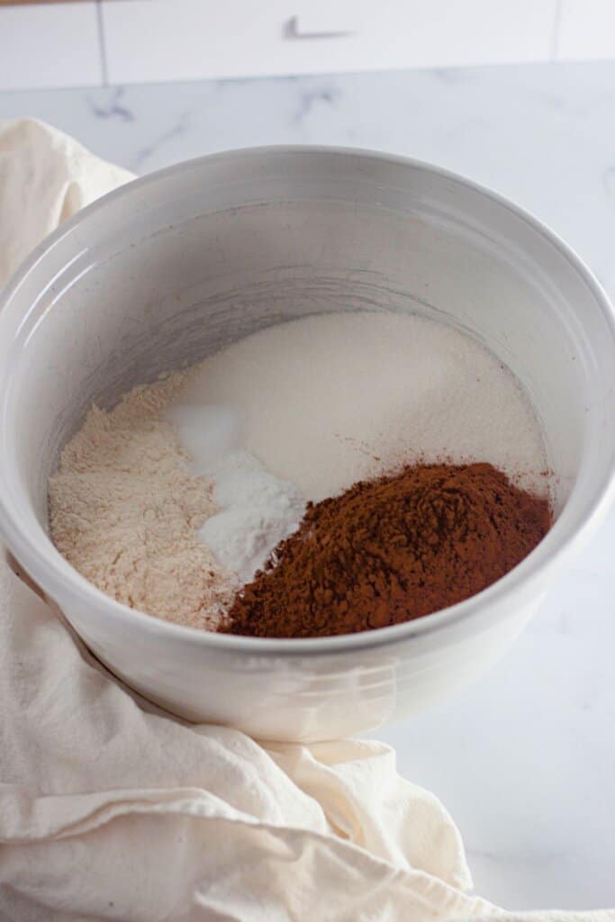 Dry ingredients being mixed in a white mixing bowl.