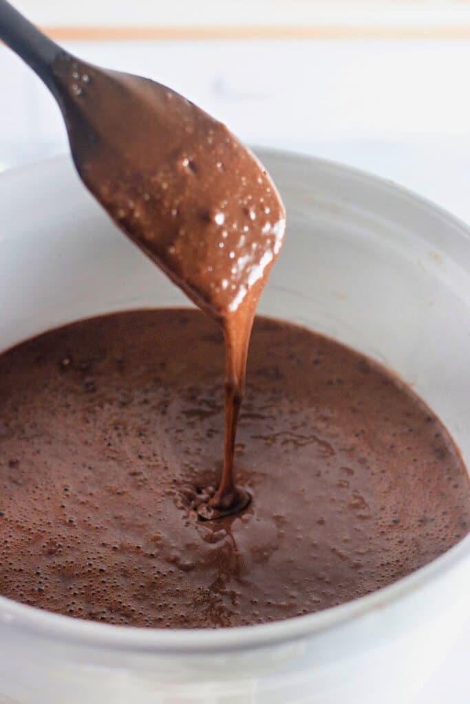 Batter being mixed in a white bowl.