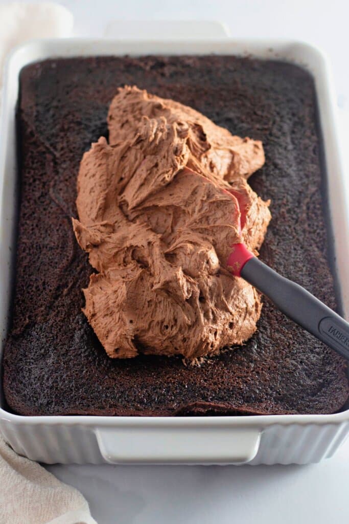 Frosting being spread on top of dessert.