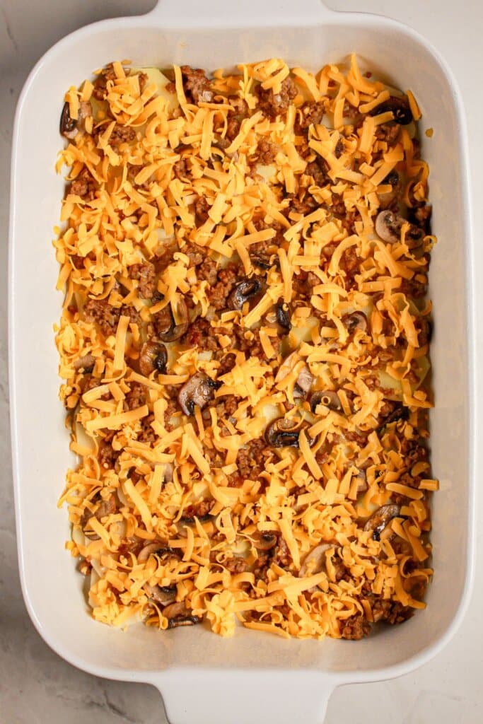 Cheese being sprinkled on top of dish.