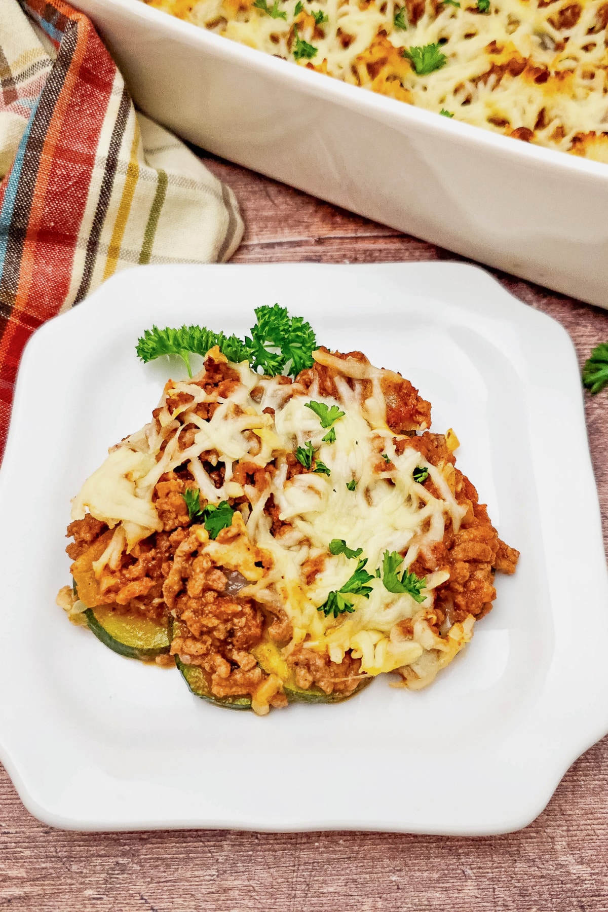 Ground beef and zucchini casserole on a white plate.
