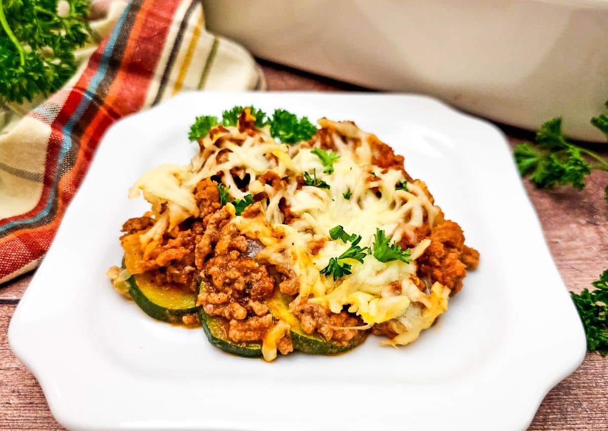 Ground beef and zucchini casserole on a white plate.