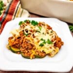 Ground beef and zucchini casserole on a white plate.