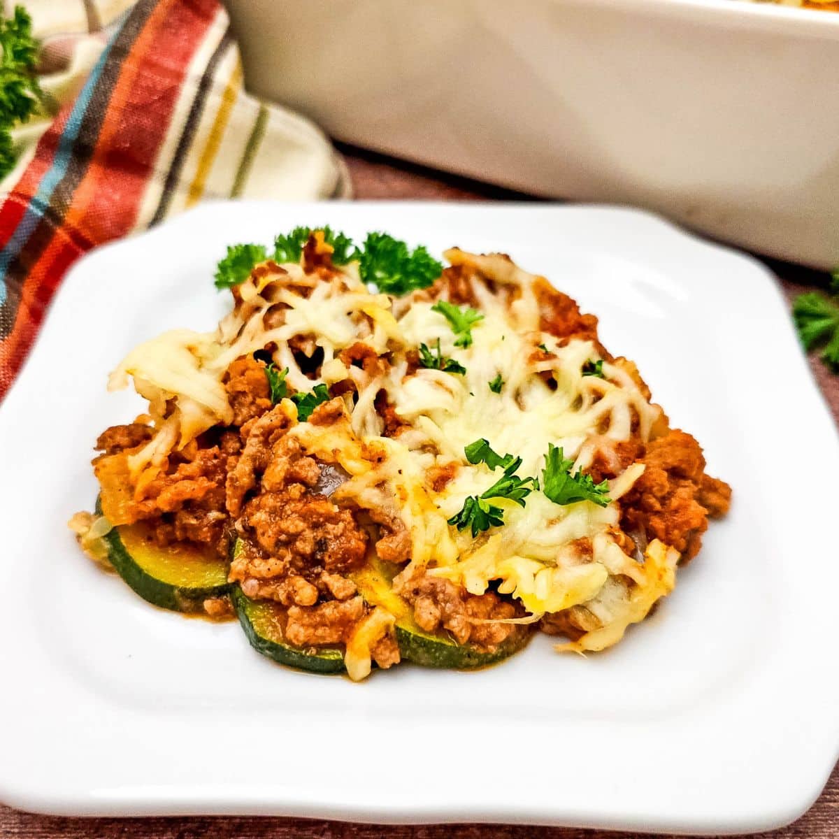 Ground beef and zucchini casserole on a white plate.