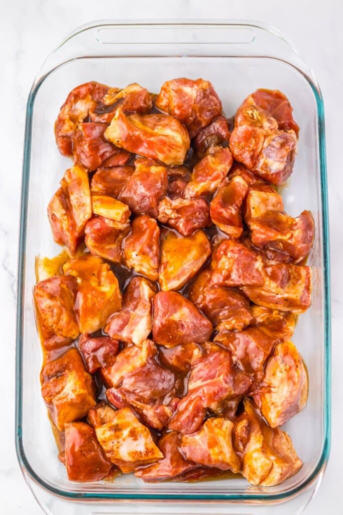 Seasoned raw meat in a glass baking dish.