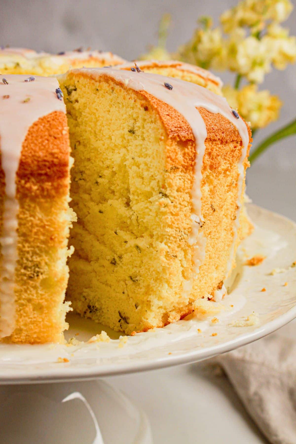 Slice of cake being removed from a cake stand.