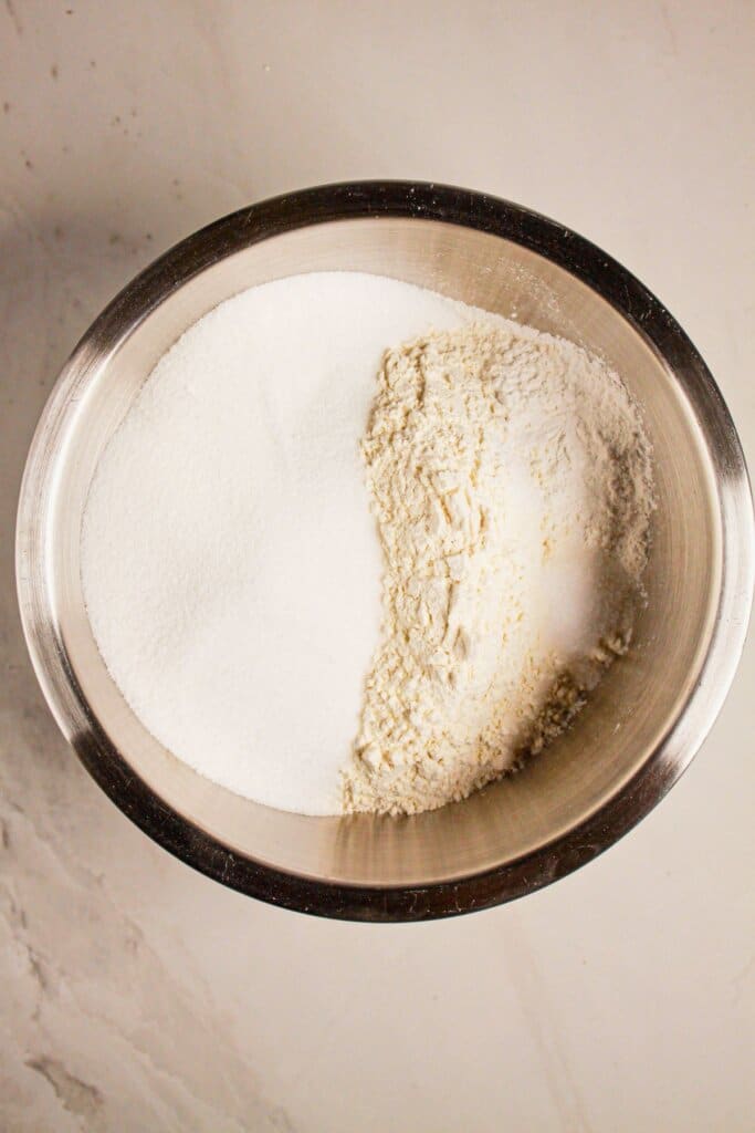 Dry ingredients being mixed in a stainless steel mixing bowl.