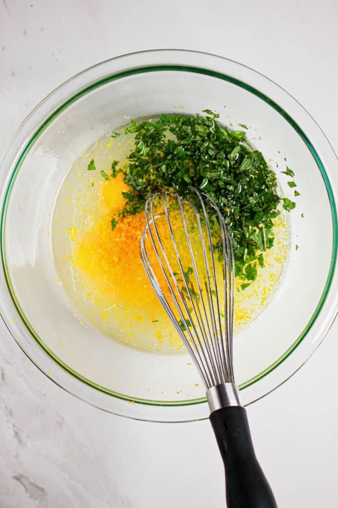 Wet ingredients being mixed in a glass bowl.