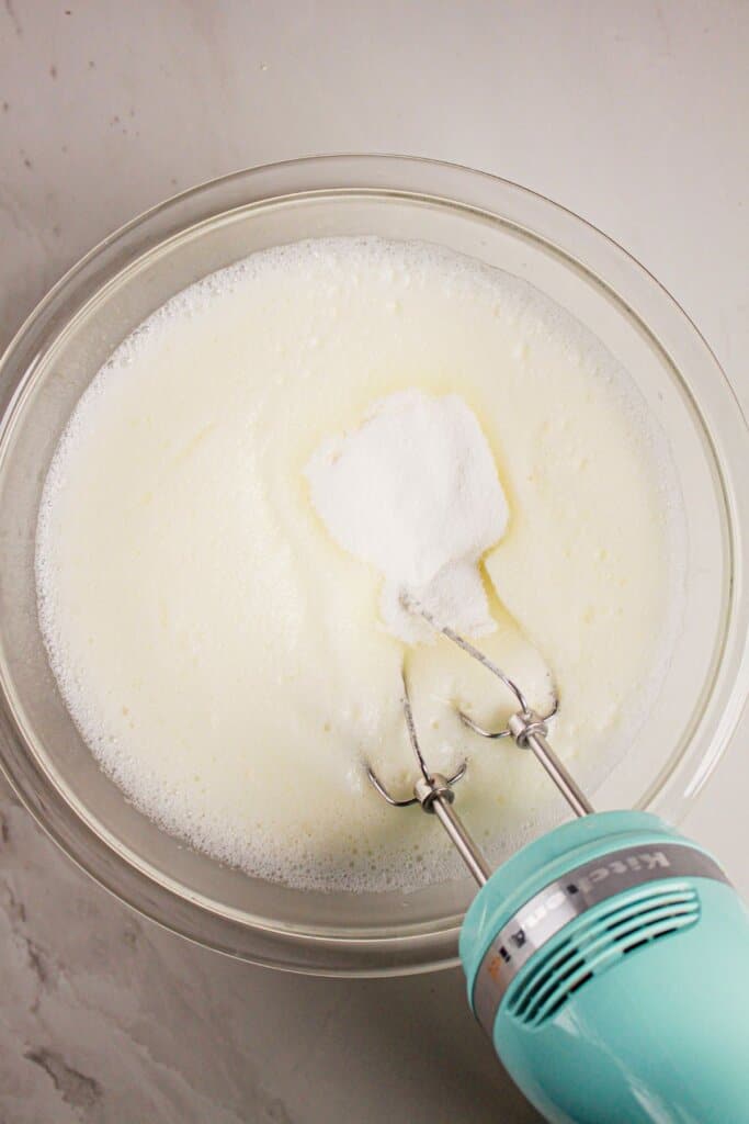 Whites being whisked in a glass bowl.