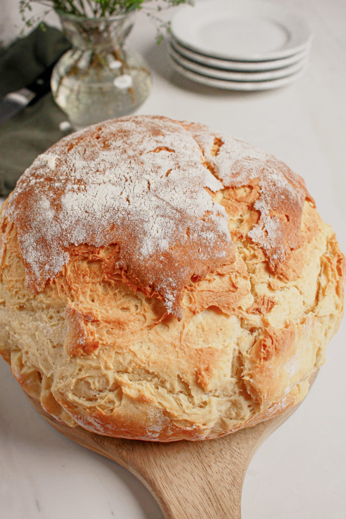 Whole loaf of mock sourdough bread on a wooden cutting board.