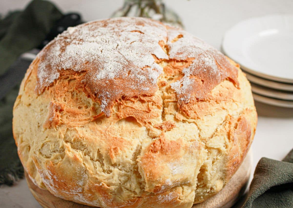 Whole loaf of mock sourdough bread on a wooden cutting board.