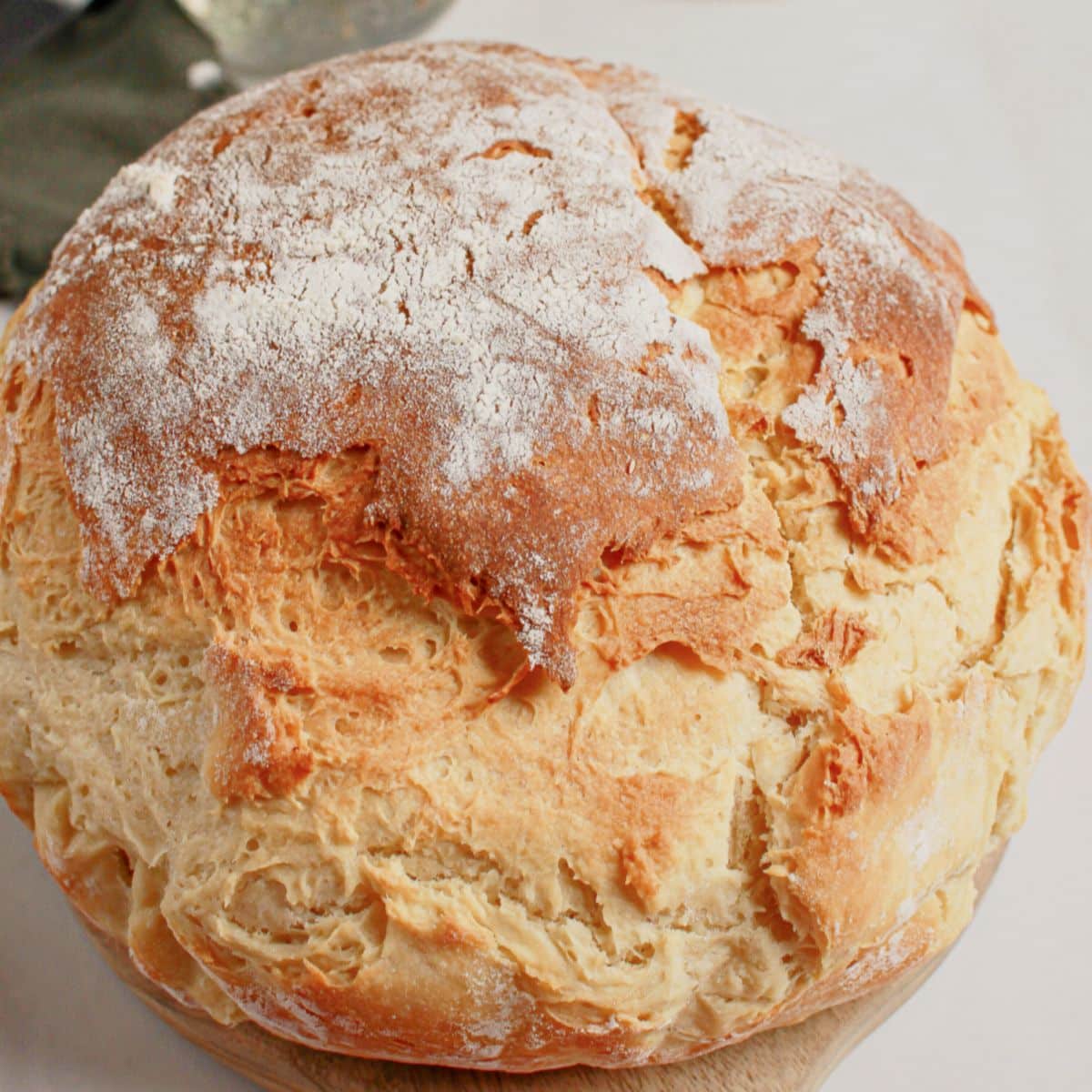 Whole loaf of mock sourdough bread on a wooden cutting board.