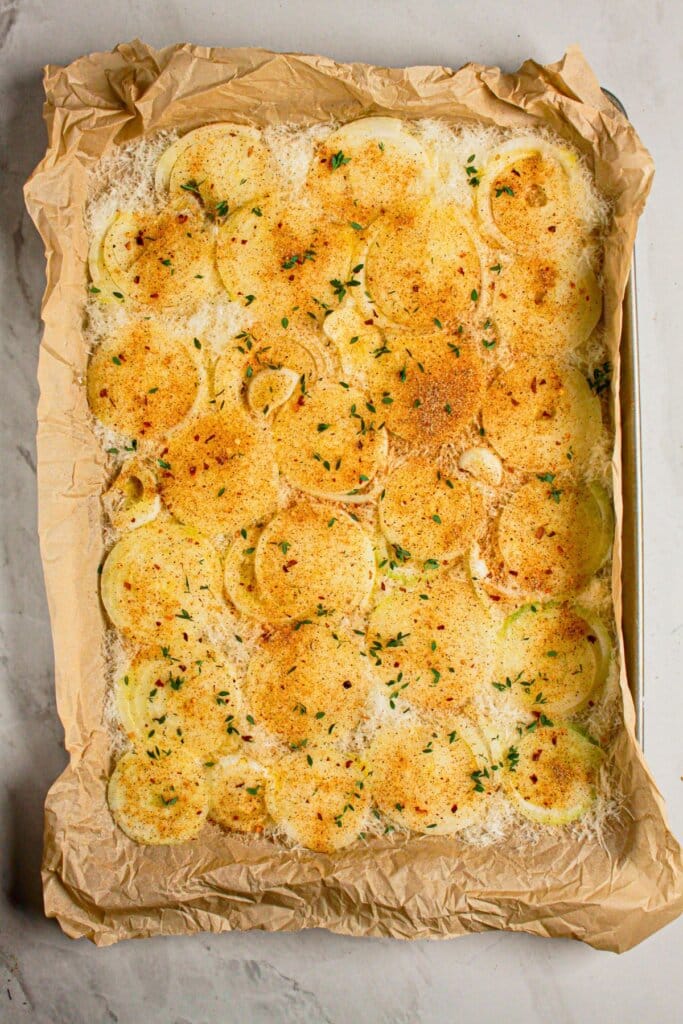 Vegetables and cheese on a parchment lined baking sheet.