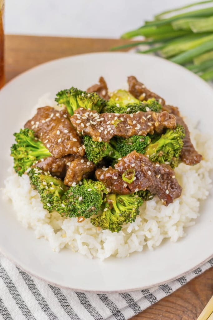White plate with rice topped with beef and broccoli.
