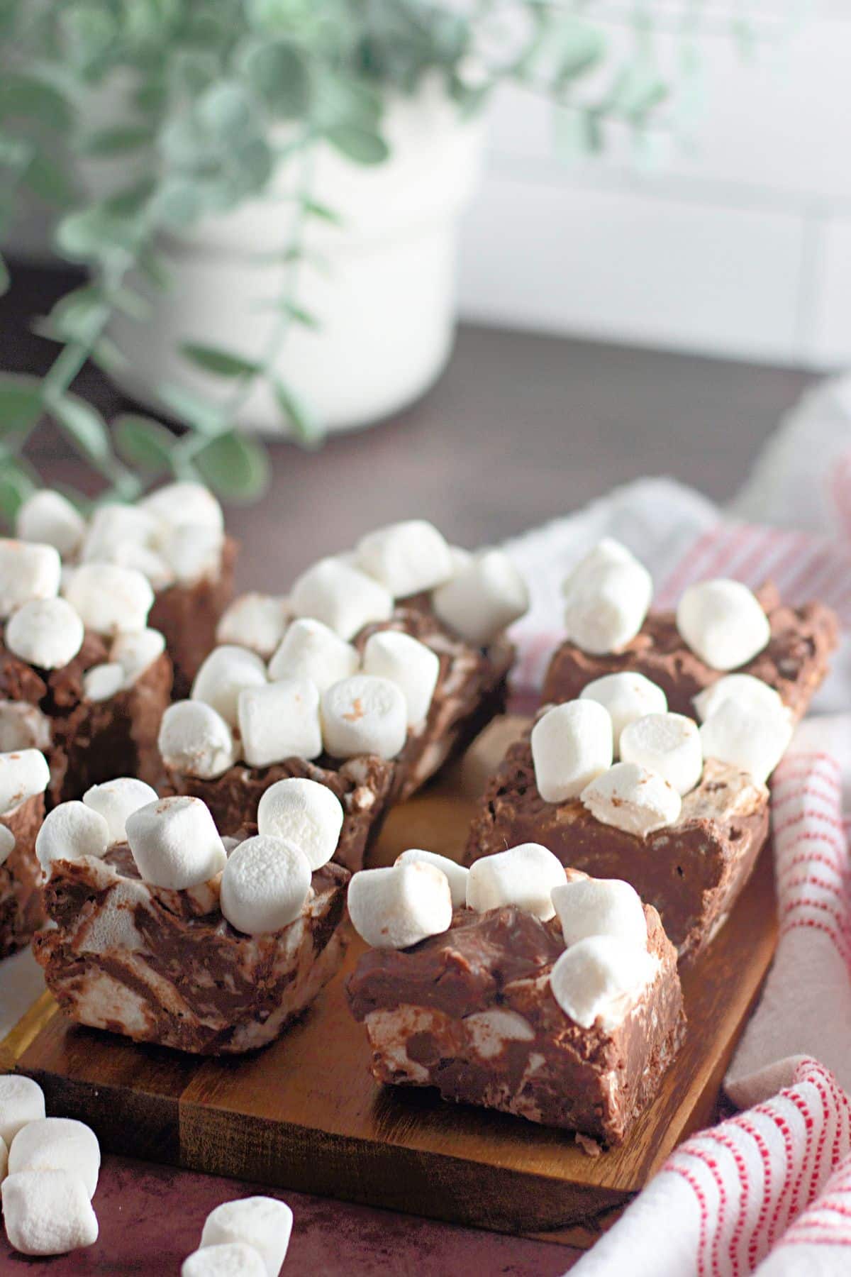 Pieces of rocky road candy bars on a wooden cutting board.
