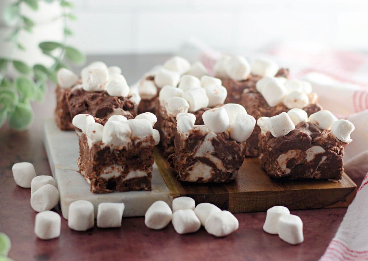 Pieces of rocky road candy bars on a wooden cutting board.