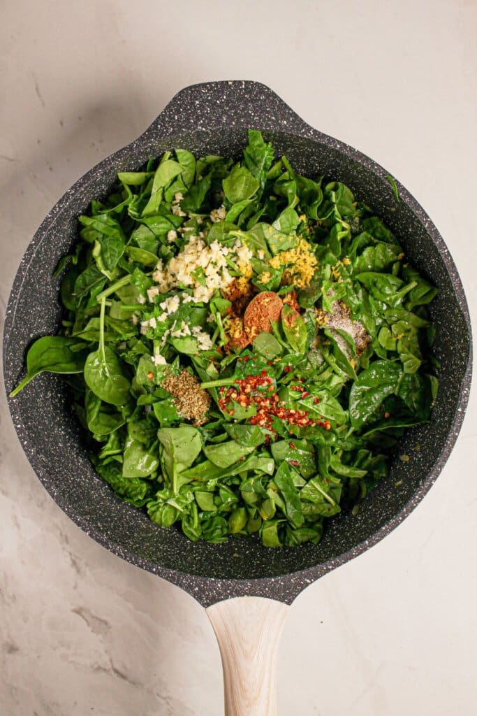 Spinach and seasonings in a large skillet.