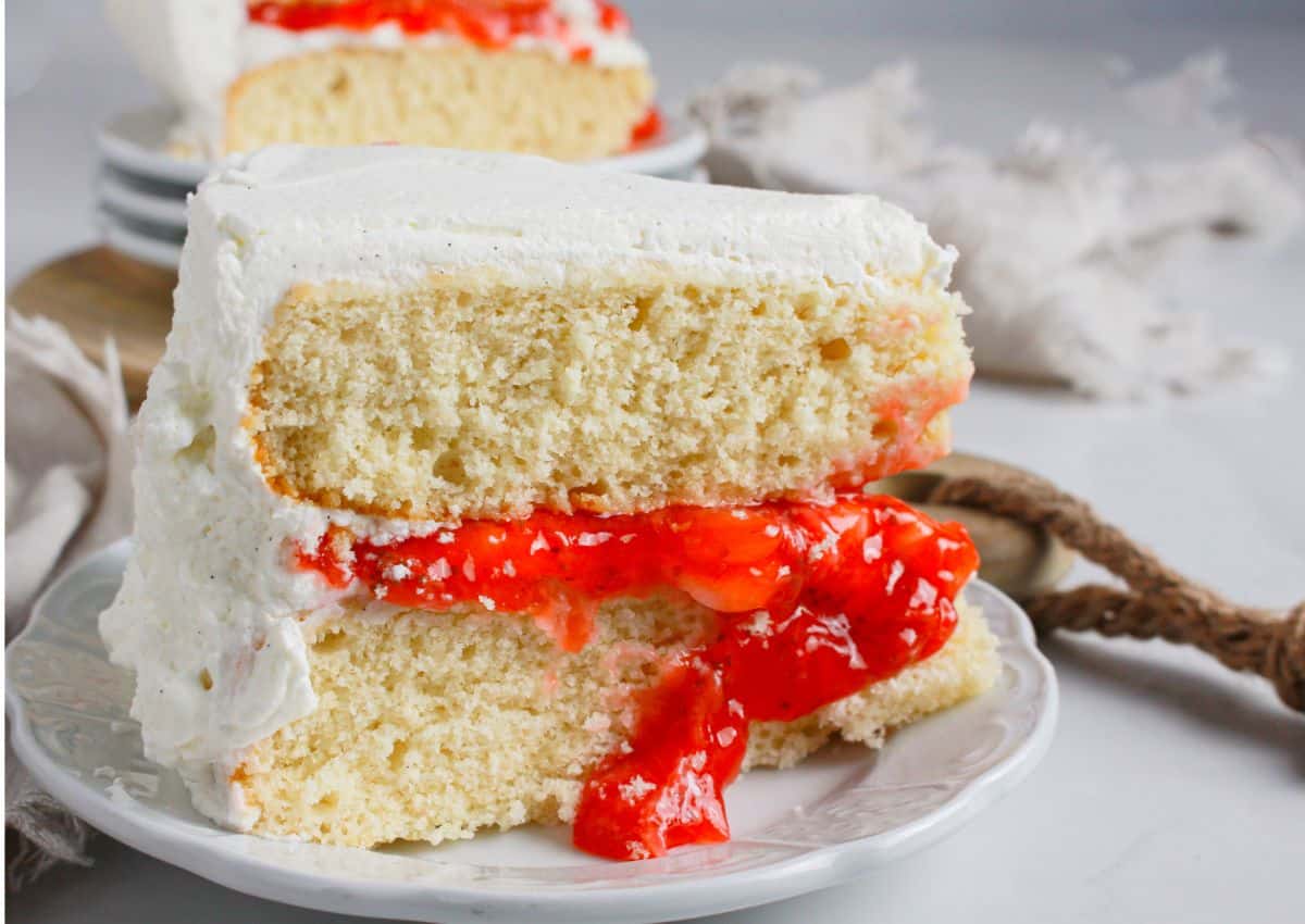 Slice of strawberry shortcake cake on a small plate.