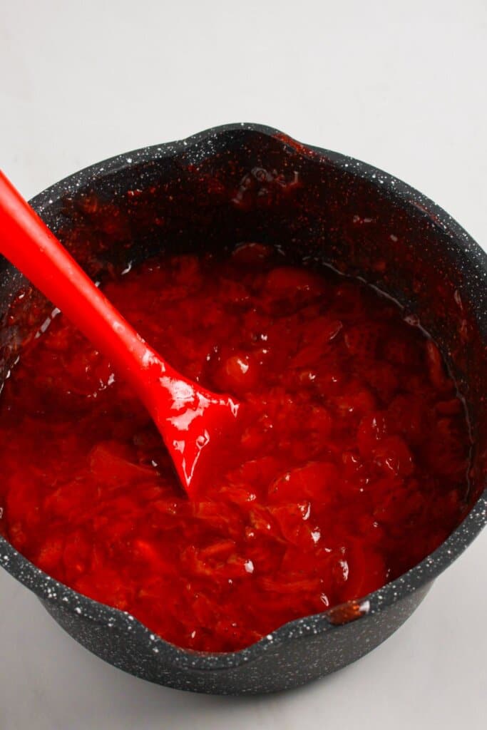 Strawberry filling being cooked in a saucepan.