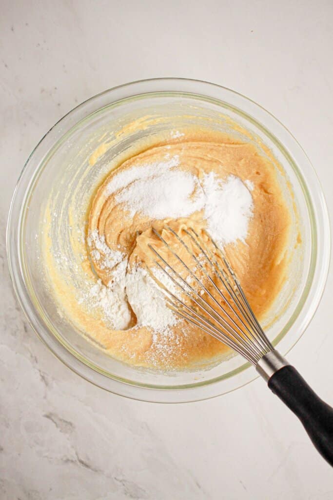 Salt and baking powder being stirred into dough.