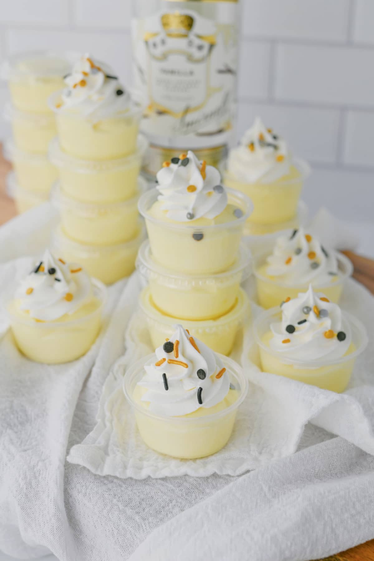 Vanilla pudding shots on a white napkin.