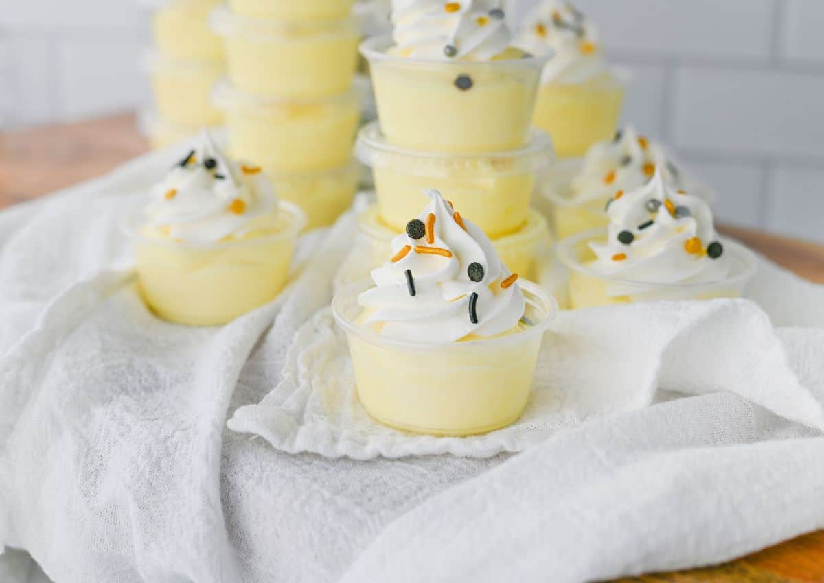 Vanilla pudding shots on a white napkin.