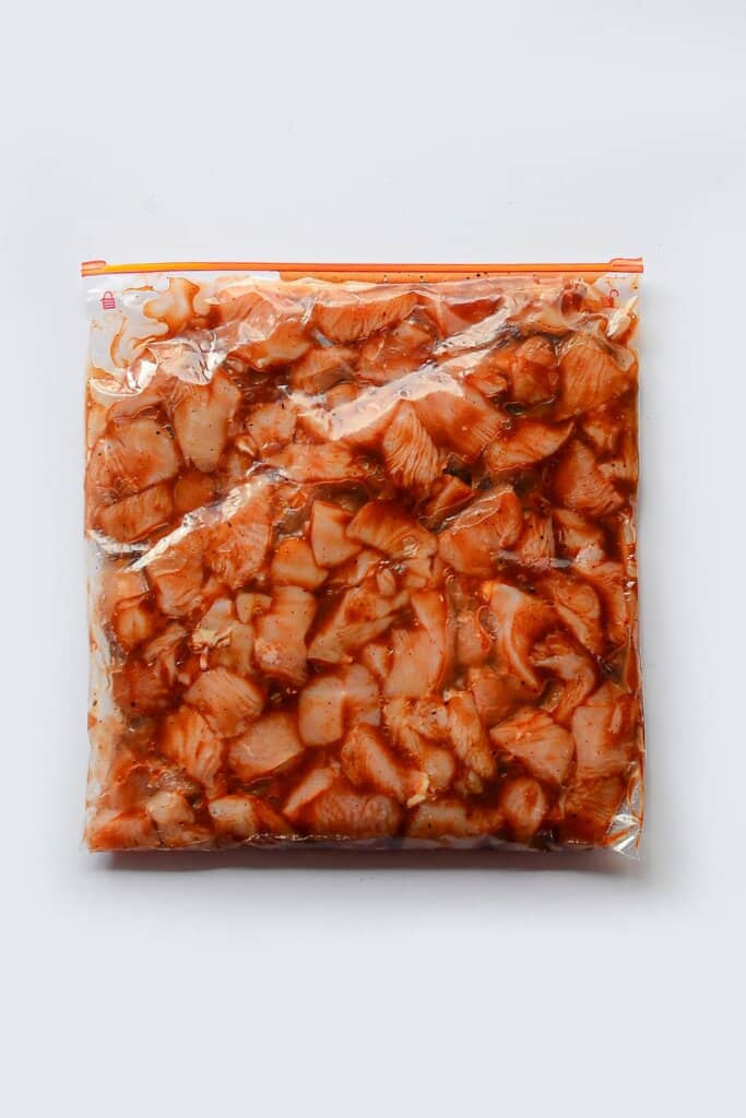 Chicken marinating in a ziploc bag.