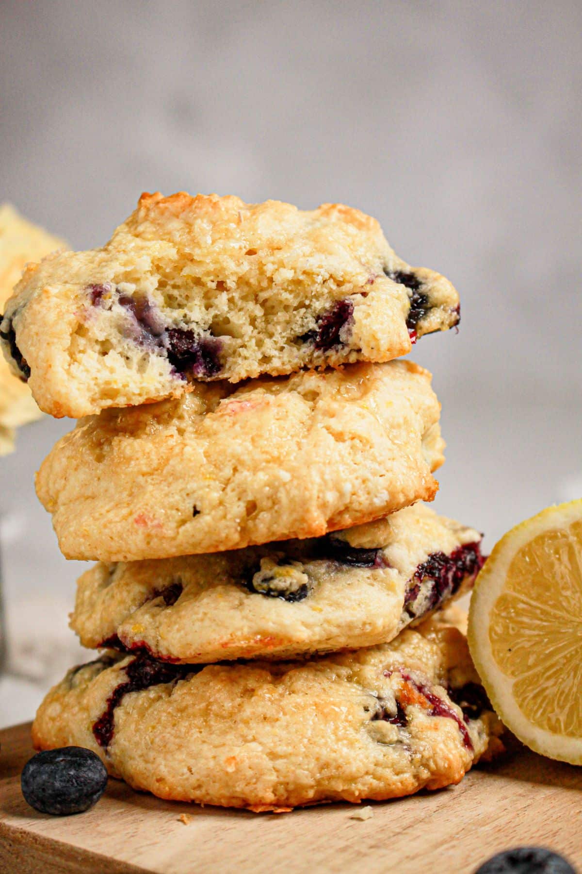 Four scones stacked on a wooden cutting board.