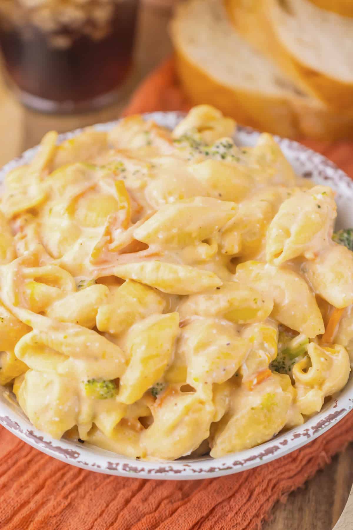 White bowl full of broccoli mac and cheese.