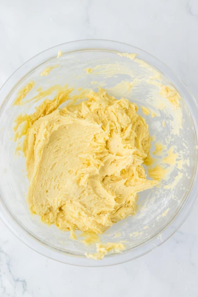 Dough being mixed in a glass mixing bowl.