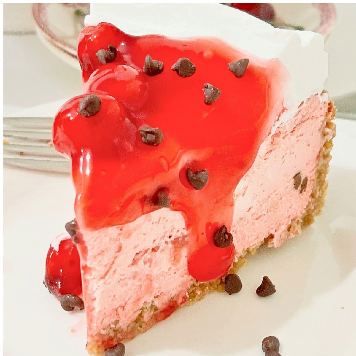 Slice of cherry chip cheesecake on a white plate.