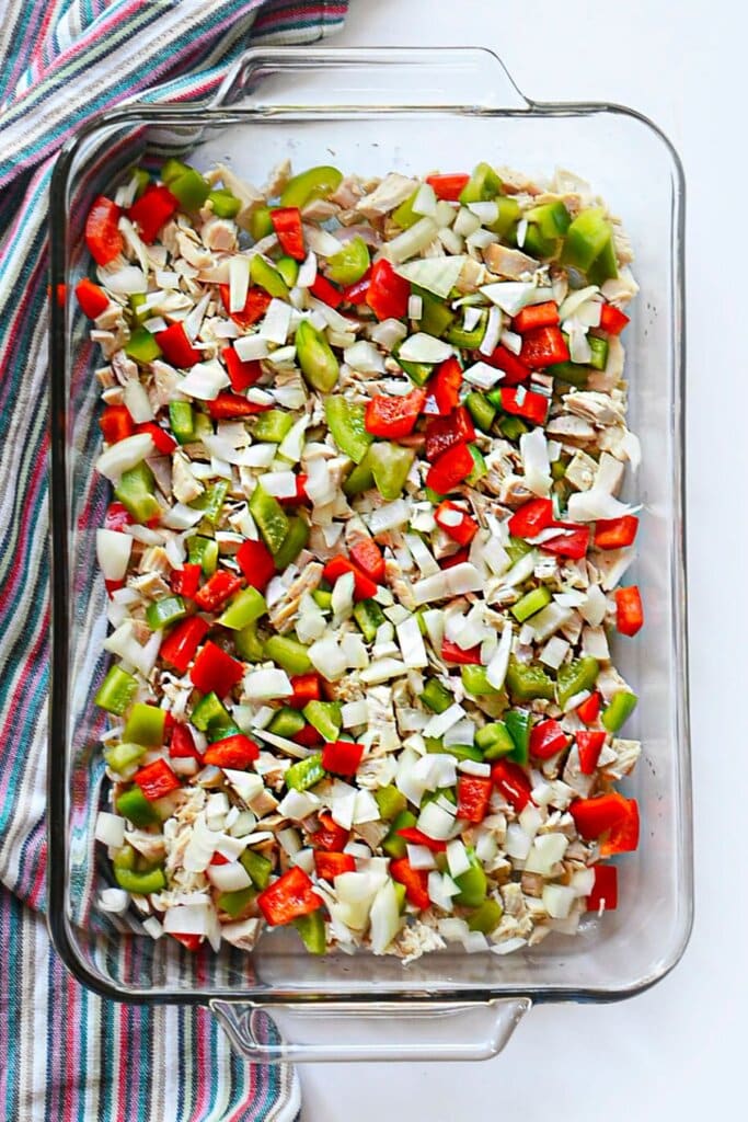 Meat and vegetables in a glass baking dish.