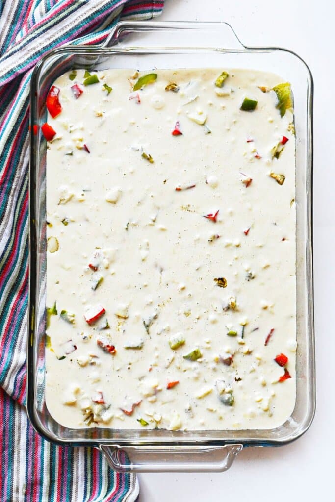 Bisquick mixture poured on top of ingredients in a baking dish.