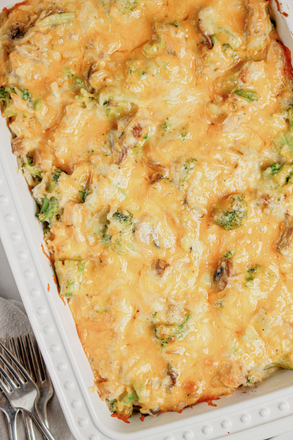 A white casserole dish full of chicken, broccoli, and rice casserole.